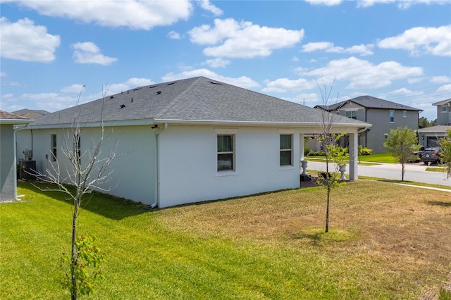 6651 Syreeta Ln, Harmony, FL 34773 - back of property with central AC, a shingled roof, a lawn, and stucco siding