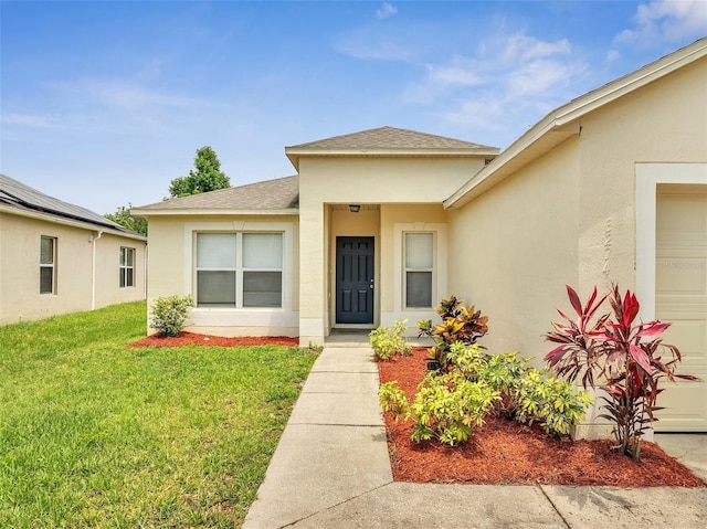 3274 Hunters Chase Loop, Kissimmee, FL 34743 - view of exterior entry with roof with shingles, stucco siding, an attached garage, and a yard