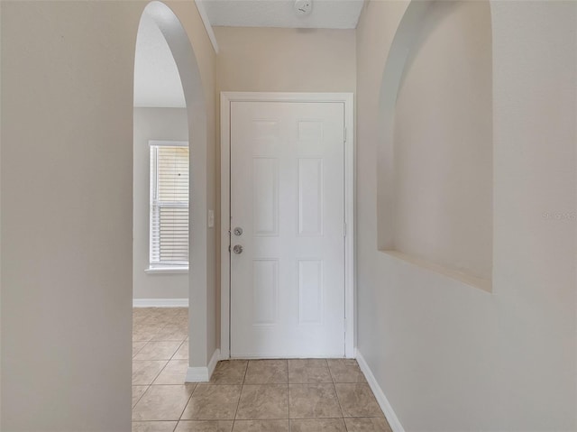 3274 Hunters Chase Loop, Kissimmee, FL 34743 - entryway featuring arched walkways, light tile patterned flooring, and baseboards