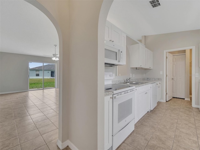 3274 Hunters Chase Loop, Kissimmee, FL 34743 - kitchen featuring white appliances, arched walkways, a sink, and light tile patterned floors