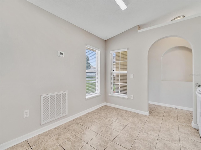3274 Hunters Chase Loop, Kissimmee, FL 34743 - unfurnished room with vaulted ceiling, light tile patterned floors, baseboards, and arched walkways