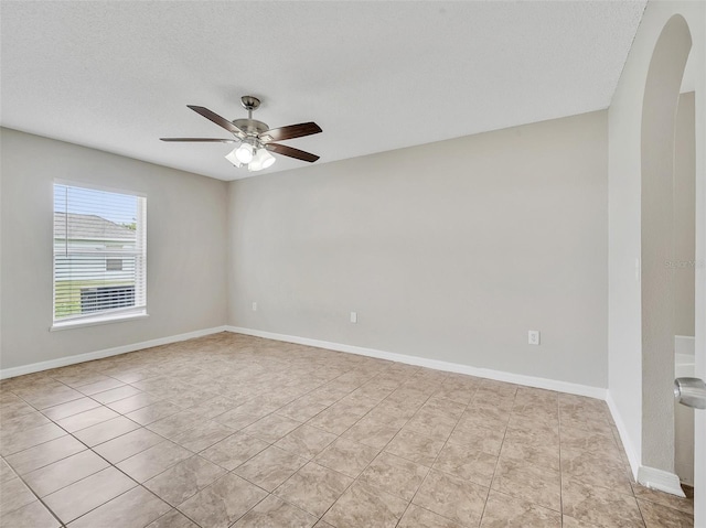 3274 Hunters Chase Loop, Kissimmee, FL 34743 - spare room with arched walkways, a ceiling fan, light tile patterned floors, baseboards, and a textured ceiling