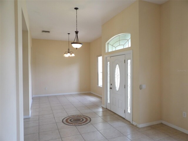 3074 Bay Laurel Cir N, Kissimmee, FL 34744 - foyer entrance featuring light tile patterned flooring, a chandelier, and baseboards