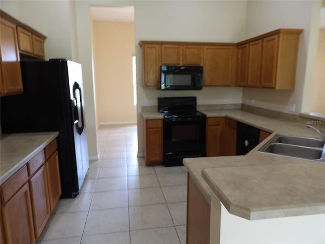 3074 Bay Laurel Cir N, Kissimmee, FL 34744 - kitchen featuring black appliances, a sink, light tile patterned floors, light countertops, and brown cabinetry