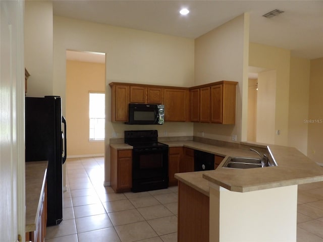 3074 Bay Laurel Cir N, Kissimmee, FL 34744 - kitchen featuring black appliances, a sink, a peninsula, light tile patterned floors, and recessed lighting