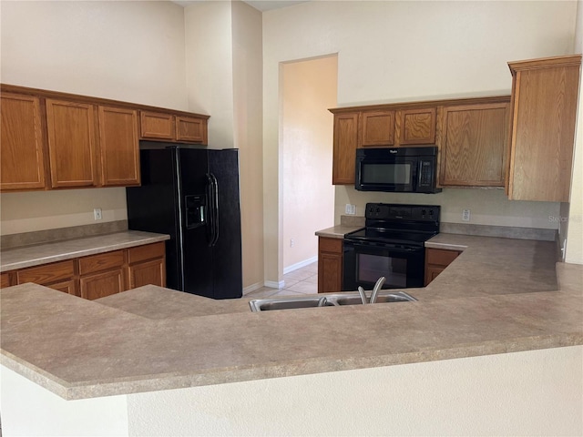3074 Bay Laurel Cir N, Kissimmee, FL 34744 - kitchen featuring black appliances, brown cabinetry, light countertops, light tile patterned floors, and a sink