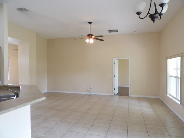 3074 Bay Laurel Cir N, Kissimmee, FL 34744 - unfurnished living room featuring light tile patterned floors, baseboards, a ceiling fan, a chandelier, and a sink