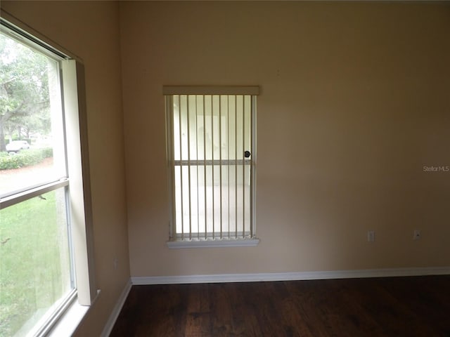 3074 Bay Laurel Cir N, Kissimmee, FL 34744 - empty room with healthy amount of natural light, wood finished floors, and baseboards
