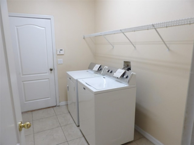 3074 Bay Laurel Cir N, Kissimmee, FL 34744 - laundry room featuring washing machine and dryer, light tile patterned flooring, and baseboards
