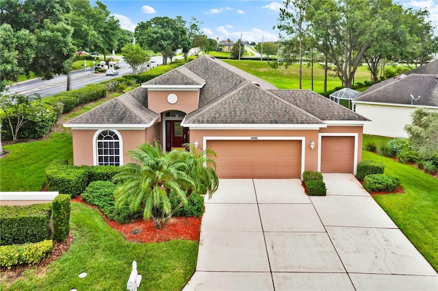 4065 Kingsley St, Clermont, FL 34711 - view of front facade with stucco siding, a garage, a shingled roof, driveway, and a front yard