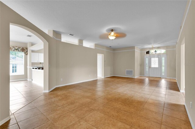 4065 Kingsley St, Clermont, FL 34711 - spare room featuring healthy amount of natural light, light tile patterned floors, arched walkways, and ceiling fan