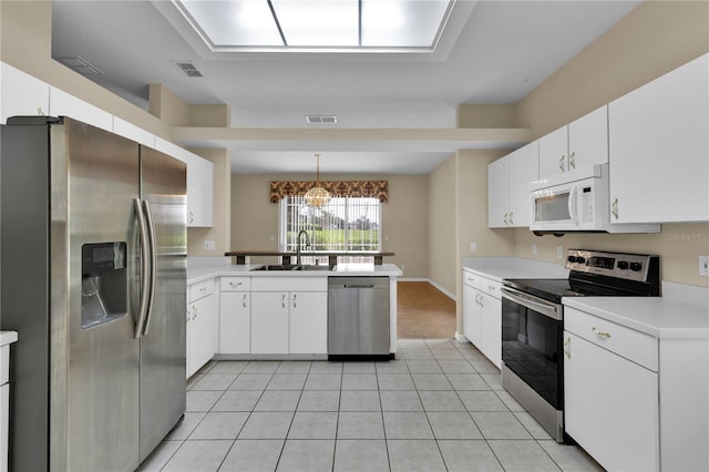 4065 Kingsley St, Clermont, FL 34711 - kitchen featuring appliances with stainless steel finishes, a peninsula, light countertops, and white cabinetry