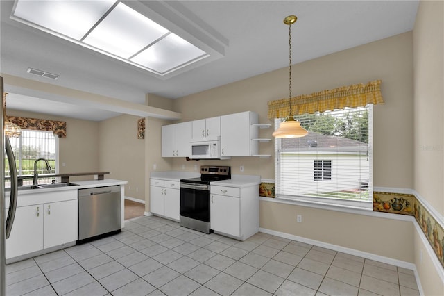 4065 Kingsley St, Clermont, FL 34711 - kitchen featuring appliances with stainless steel finishes, light countertops, white cabinets, pendant lighting, and light tile patterned floors