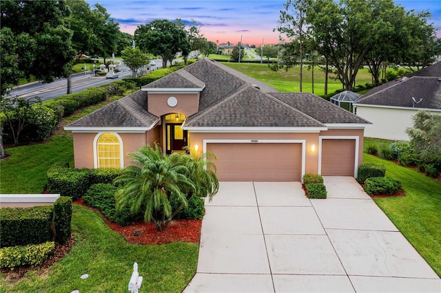 4065 Kingsley St, Clermont, FL 34711 - view of front of house featuring stucco siding, an attached garage, concrete driveway, a shingled roof, and a front lawn