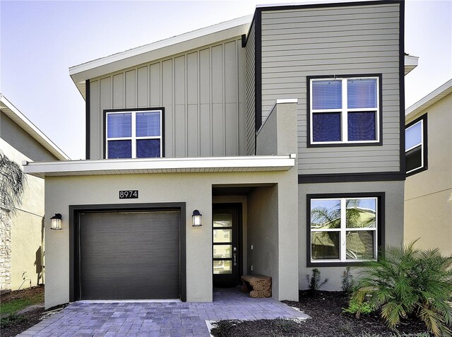 8974 Cabot Cliffs Dr, Davenport, FL 33896 - view of front of property with board and batten siding, a garage, and stucco siding