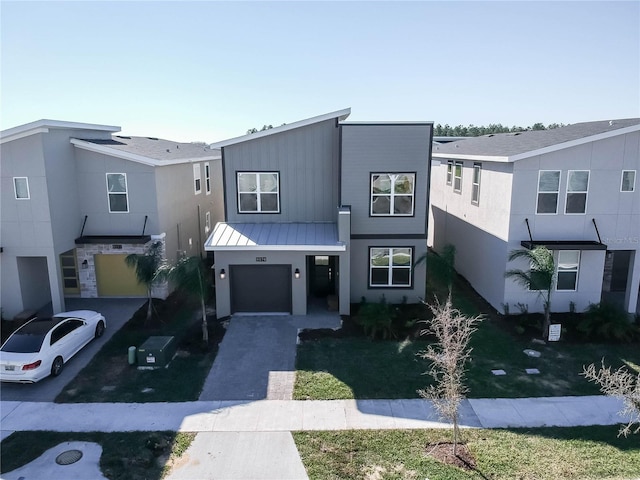 8974 Cabot Cliffs Dr, Davenport, FL 33896 - view of front facade with driveway, a standing seam roof, an attached garage, stucco siding, and metal roof
