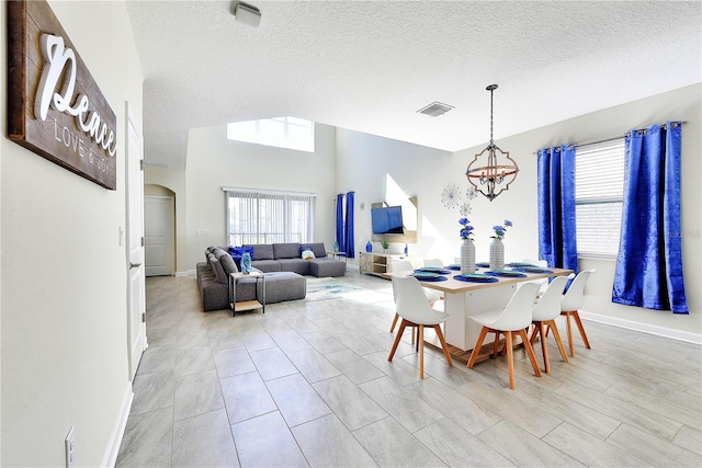 8974 Cabot Cliffs Dr, Davenport, FL 33896 - dining space with a chandelier, a textured ceiling, baseboards, and arched walkways