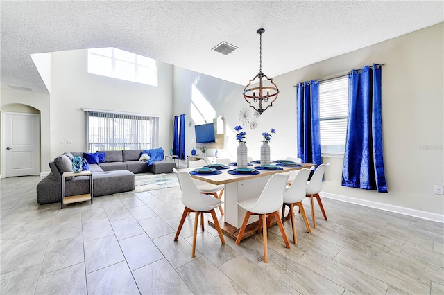 8974 Cabot Cliffs Dr, Davenport, FL 33896 - dining area featuring a textured ceiling, a chandelier, arched walkways, and baseboards