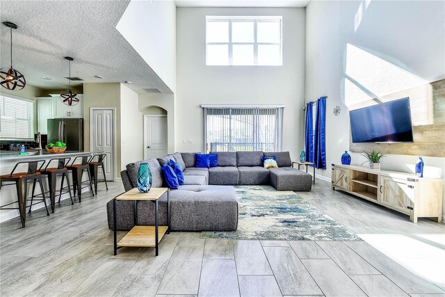 8974 Cabot Cliffs Dr, Davenport, FL 33896 - living room with arched walkways, a towering ceiling, healthy amount of natural light, and ceiling fan