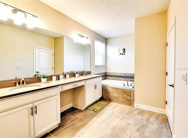 8974 Cabot Cliffs Dr, Davenport, FL 33896 - full bathroom featuring double vanity, a bath, and a textured ceiling