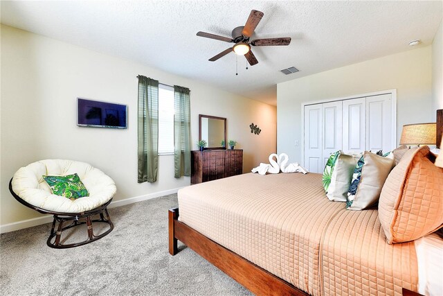 8974 Cabot Cliffs Dr, Davenport, FL 33896 - carpeted bedroom with baseboards, ceiling fan, a closet, and a textured ceiling