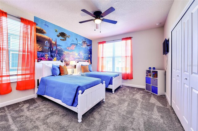 8974 Cabot Cliffs Dr, Davenport, FL 33896 - carpeted bedroom featuring a textured ceiling, baseboards, a closet, and a ceiling fan