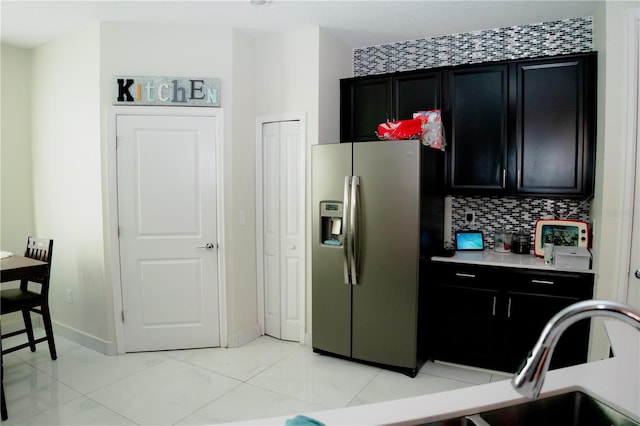 153 Taft Dr, Davenport, FL 33837 - kitchen featuring stainless steel fridge, dark cabinets, light countertops, and backsplash