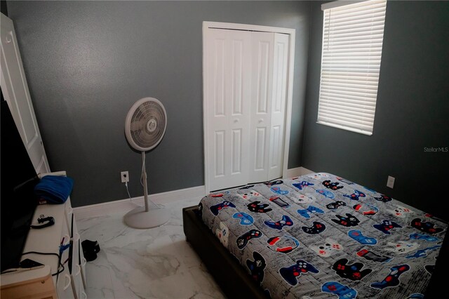 153 Taft Dr, Davenport, FL 33837 - bedroom featuring marble look tiles, a closet, and baseboards