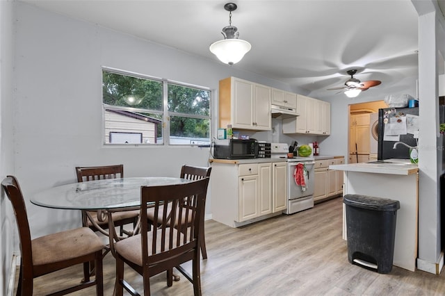 5381 Avocado Ave, Cocoa, FL 32926 - kitchen with white electric stove, under cabinet range hood, a sink, freestanding refrigerator, and light wood-style flooring