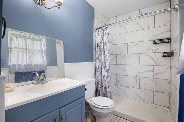 5381 Avocado Ave, Cocoa, FL 32926 - bathroom with toilet, vanity, tiled shower, and a wainscoted wall