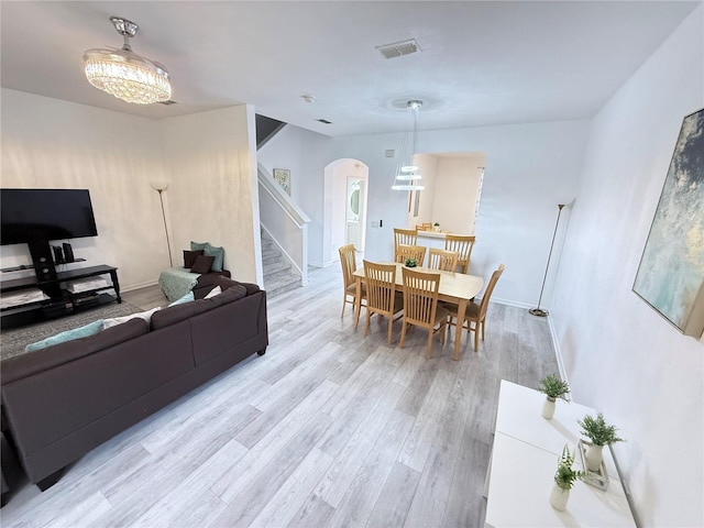 615 Terra Lago St, Davenport, FL 33897 - living room with arched walkways, light wood-style floors, stairway, and a chandelier