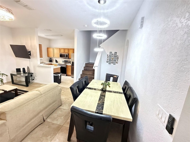 324 Palermo St, Davenport, FL 33897 - dining area with light tile patterned floors, a textured wall, stairway, and arched walkways