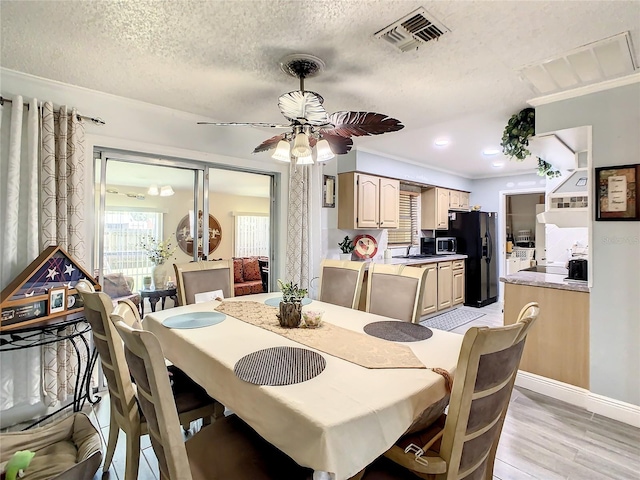 624 Royal Palm Dr, Kissimmee, FL 34743 - dining room with light wood-style floors, a textured ceiling, a ceiling fan, and ornamental molding