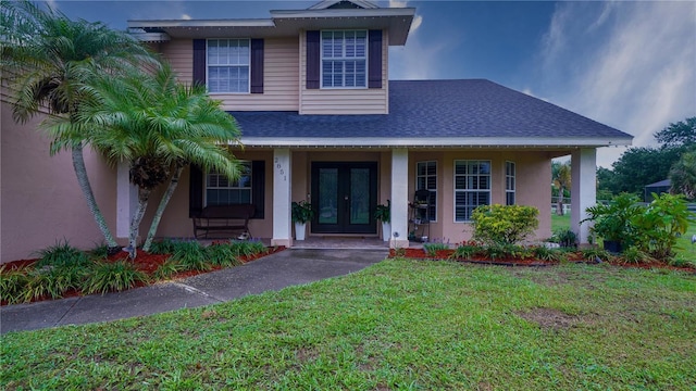2851 Granada Blvd, Kissimmee, FL 34746 - view of front of home featuring french doors, a front yard, covered porch, a shingled roof, and stucco siding