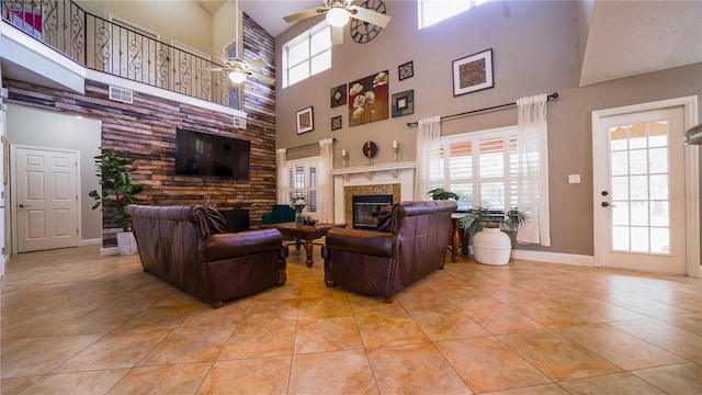 2851 Granada Blvd, Kissimmee, FL 34746 - living area with a glass covered fireplace, ceiling fan, a high ceiling, and light tile patterned flooring