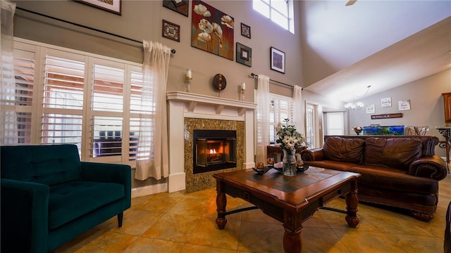 2851 Granada Blvd, Kissimmee, FL 34746 - tiled living room featuring a premium fireplace, a chandelier, and a towering ceiling