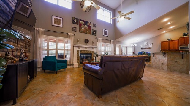 2851 Granada Blvd, Kissimmee, FL 34746 - living area featuring ceiling fan, a tile fireplace, light tile patterned flooring, and high vaulted ceiling