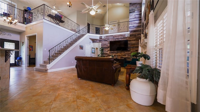 2851 Granada Blvd, Kissimmee, FL 34746 - living area with a towering ceiling, ceiling fan, stairs, tile patterned flooring, and a fireplace