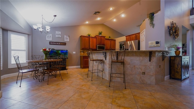 2851 Granada Blvd, Kissimmee, FL 34746 - kitchen featuring appliances with stainless steel finishes, a chandelier, a breakfast bar, lofted ceiling, and stone countertops