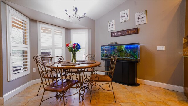 2851 Granada Blvd, Kissimmee, FL 34746 - dining room with light tile patterned floors, a chandelier, and vaulted ceiling