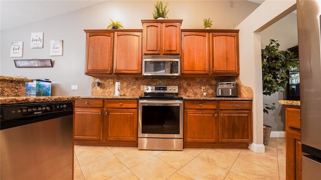 2851 Granada Blvd, Kissimmee, FL 34746 - kitchen with appliances with stainless steel finishes, vaulted ceiling, backsplash, stone counters, and light tile patterned flooring