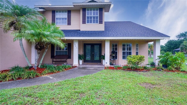 2851 Granada Blvd, Kissimmee, FL 34746 - view of front of home featuring french doors, a front yard, a porch, a shingled roof, and stucco siding