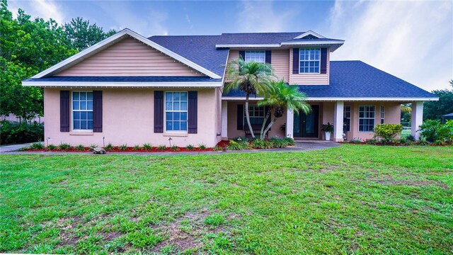 2851 Granada Blvd, Kissimmee, FL 34746 - view of front facade featuring stucco siding, a front yard, and roof with shingles