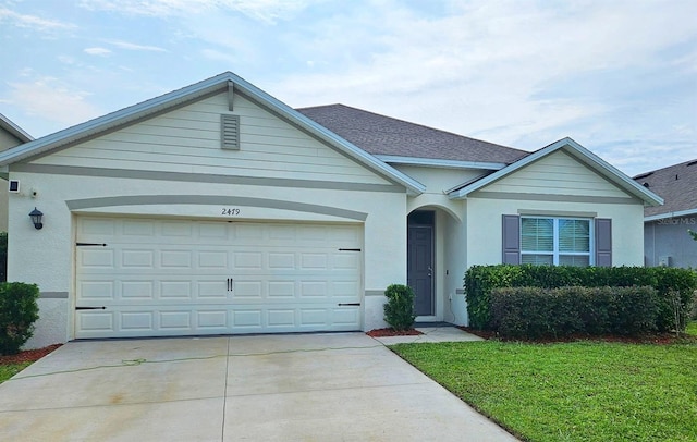 2479 White Lilly Dr, Kissimmee, FL 34747 - view of front of home featuring concrete driveway, an attached garage, stucco siding, and a front lawn