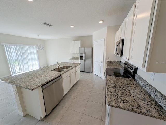 2479 White Lilly Dr, Kissimmee, FL 34747 - kitchen with appliances with stainless steel finishes, a sink, a center island with sink, light tile patterned flooring, and white cabinetry