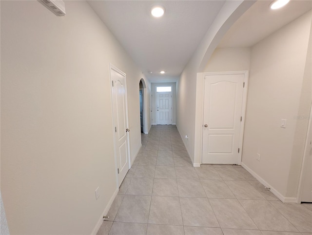 2479 White Lilly Dr, Kissimmee, FL 34747 - hallway with arched walkways, light tile patterned floors, recessed lighting, and baseboards