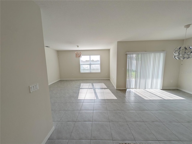 2479 White Lilly Dr, Kissimmee, FL 34747 - empty room with a chandelier, tile patterned floors, and baseboards