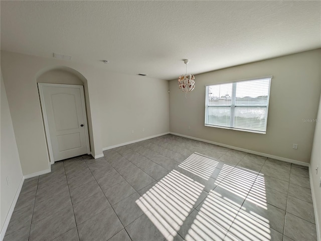 2479 White Lilly Dr, Kissimmee, FL 34747 - spare room with light tile patterned floors, a chandelier, a textured ceiling, and baseboards