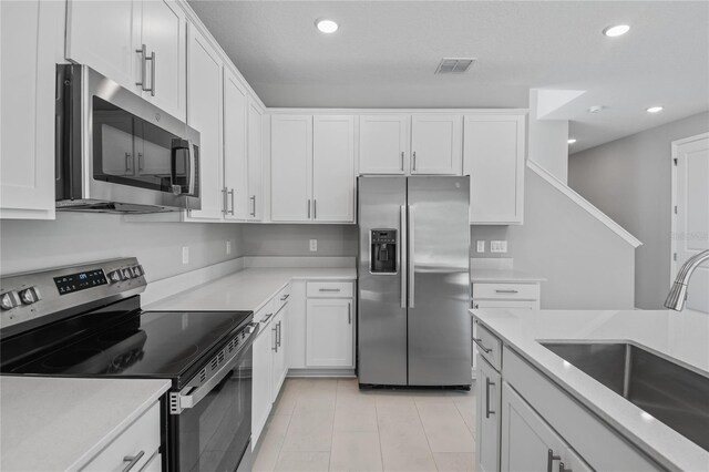 555 Summit River Dr, Apopka, FL 32712 - kitchen with appliances with stainless steel finishes, a sink, recessed lighting, white cabinetry, and light countertops
