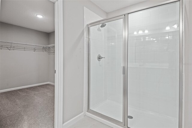 555 Summit River Dr, Apopka, FL 32712 - full bathroom featuring a shower stall, a walk in closet, and baseboards